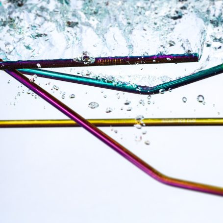 Website Content Creation Colourful metal straws partially submerged in bubbling water.